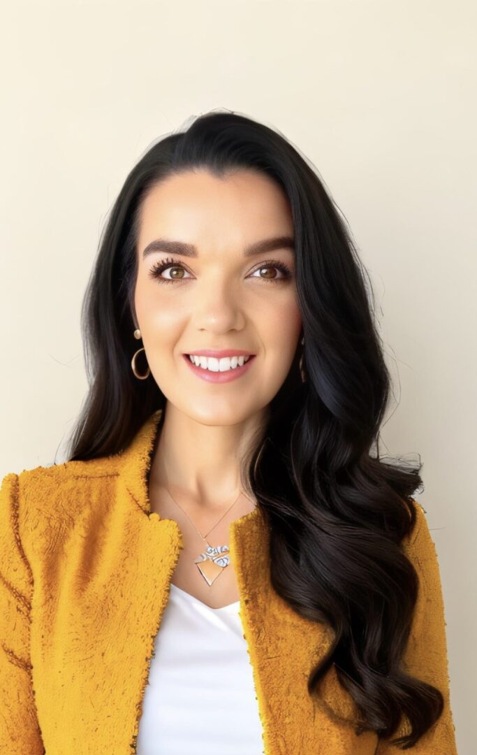 A woman in an orange jacket smiling for the camera.